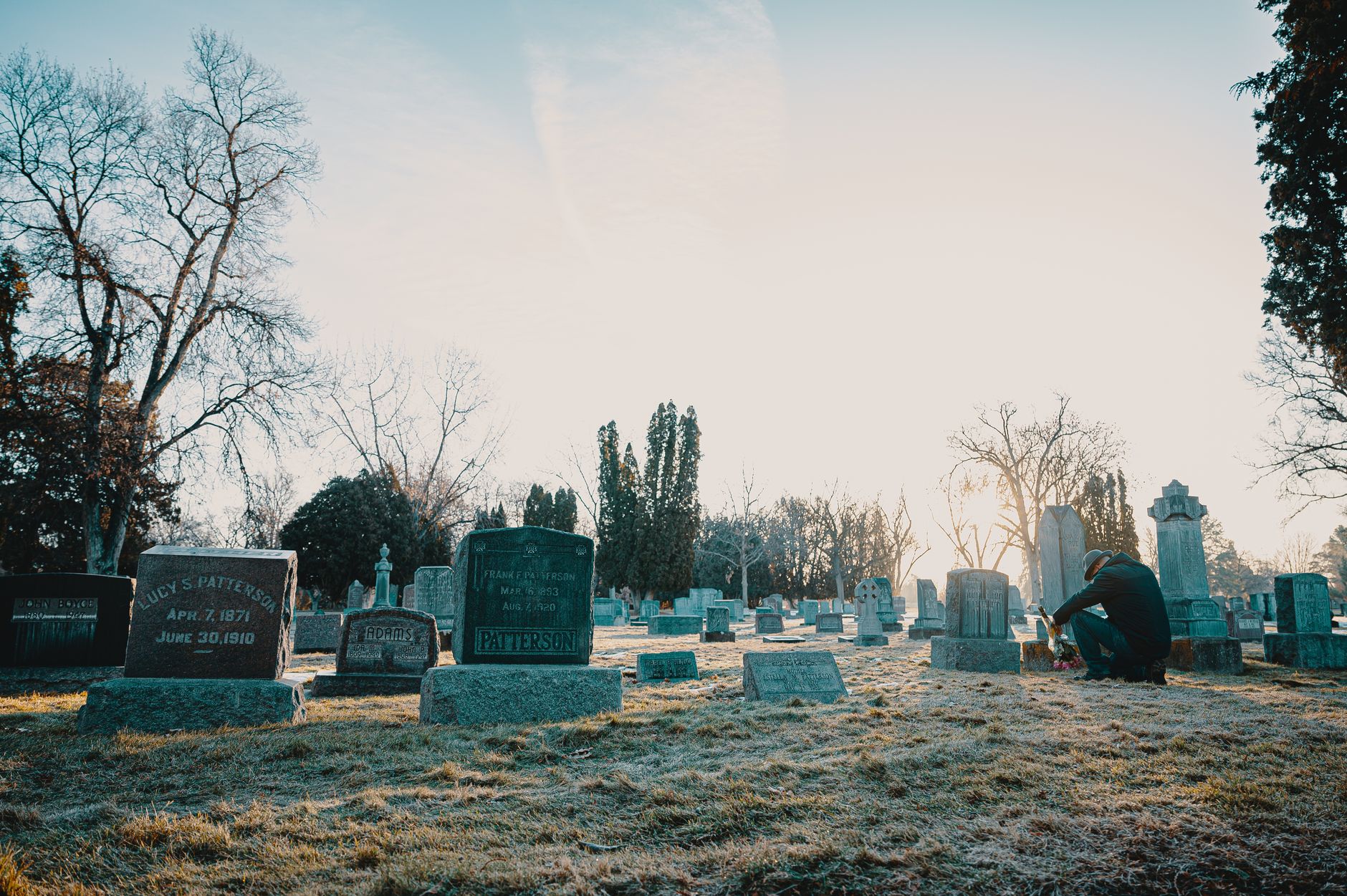 A serene cemetery at sunrise with soft golden light