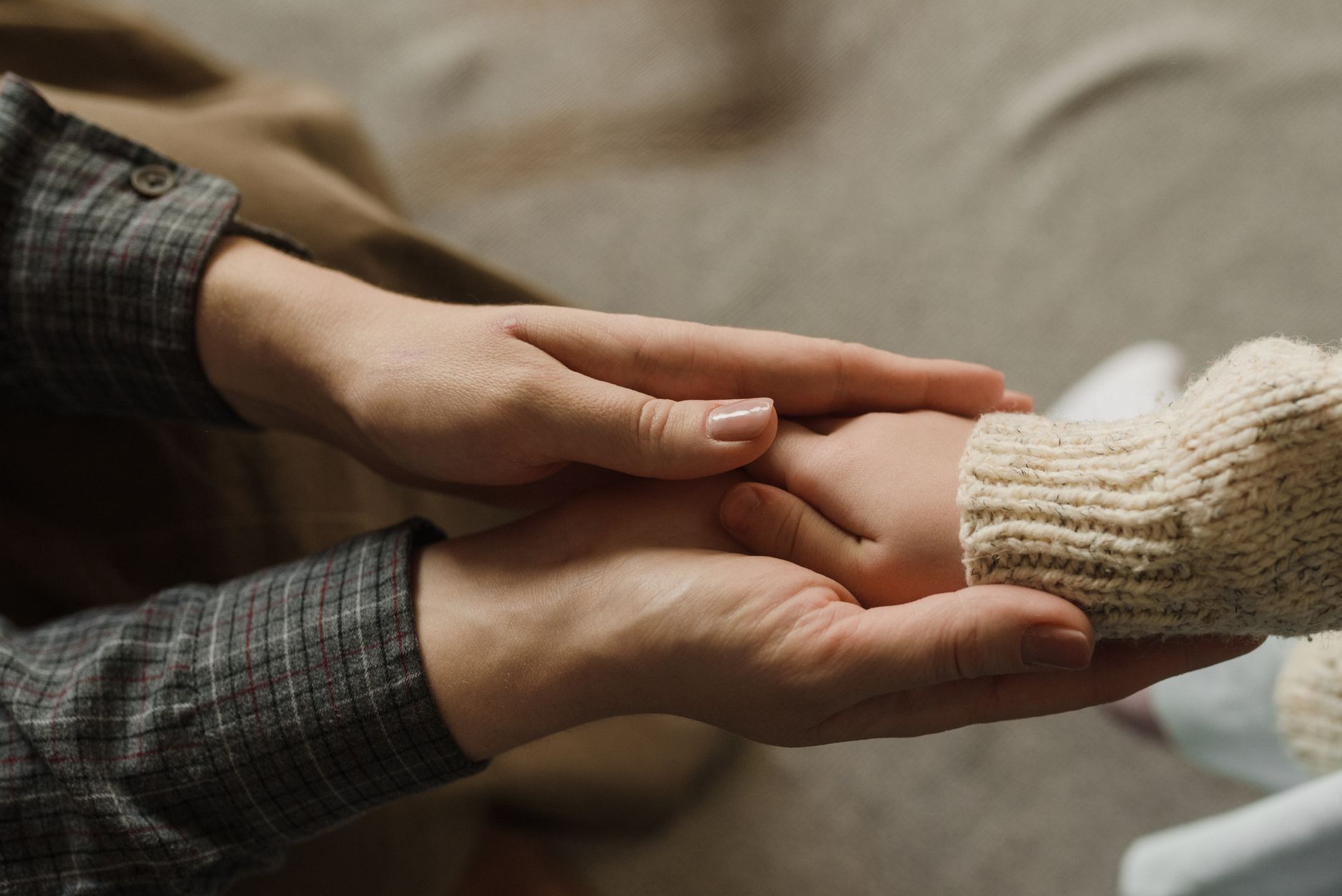 Two hands gently held together in a gesture of comfort and care