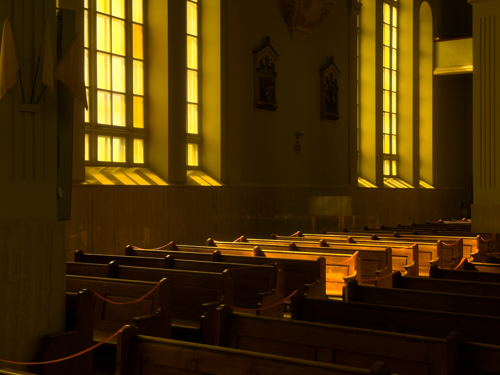 Warm golden sunlight streaming through church pews